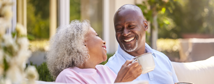 Life Assure Senior Woman Sitting In Chair And Laughing With Caregiver Nurse Hero